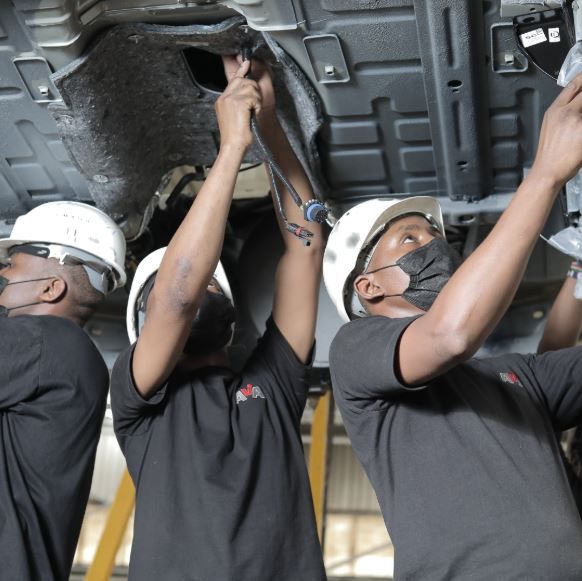 Mechanic inspecting a vehicle’s suspension for bad sway bar link symptoms